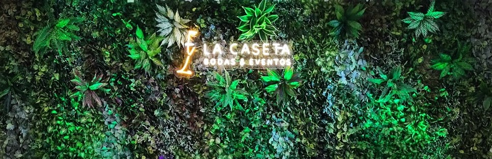 Muro vegetal iluminado con logo de Salón La Caseta, decoración premium para bodas en Montoro
