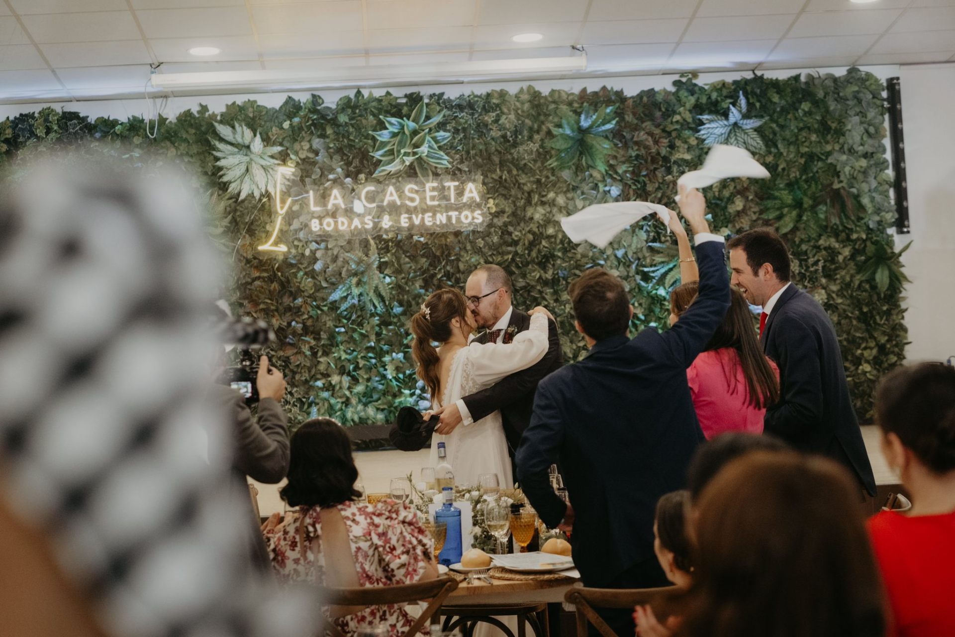 Pareja de novios celebrando su boda con muro vegetal de fondo en Salón La Caseta, eventos en Montoro Córdoba